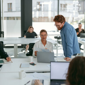 Employees engaged in office tasks and discussions.