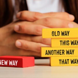 Block with "old way" and "another way" written on it, symbolizing choice between traditional and alternative methods and change management.