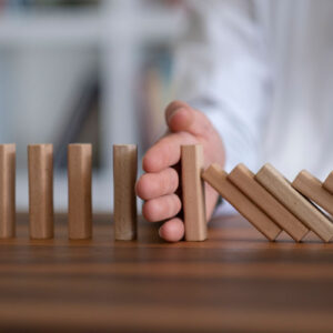 Person holding falling wooden block, symbolizing Change Management.