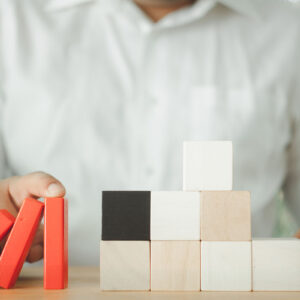 Person holding falling wooden block, symbolizing Change Management.