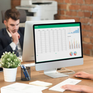 A woman working with a computer on an excel sheet in and office space.