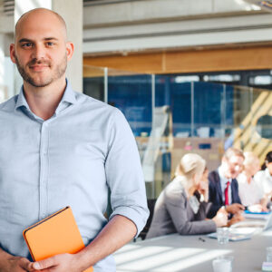 A man standing in front of a group of people who are focused on their work.