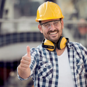 A person wearing a helmet and headphones giving a thumbs up.