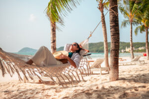 Woman relaxing in a hammock on a beach